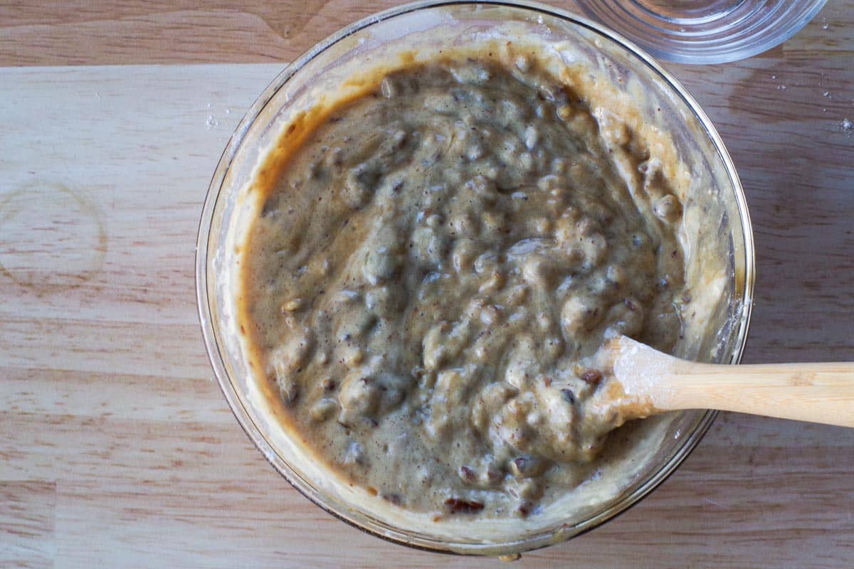 lemon juice added to mixture in a glass bowl with wooden spoon