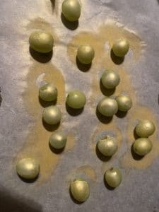 grapes sprayed with gold spray on parchment paper