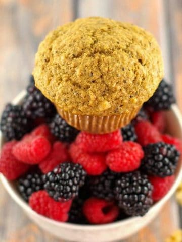 bran muffin sitting on a bowl of berries