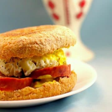 Ukrainian Breakfast Egg Sandwich on a white plate with a Ukrainian print vase in the background