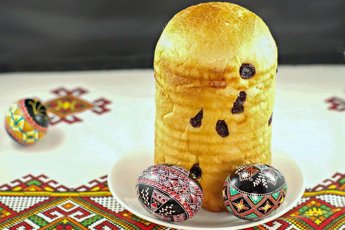 Babka on a white plate, with Ukrainian Easter eggs. on a Ukrainian print tablecloth