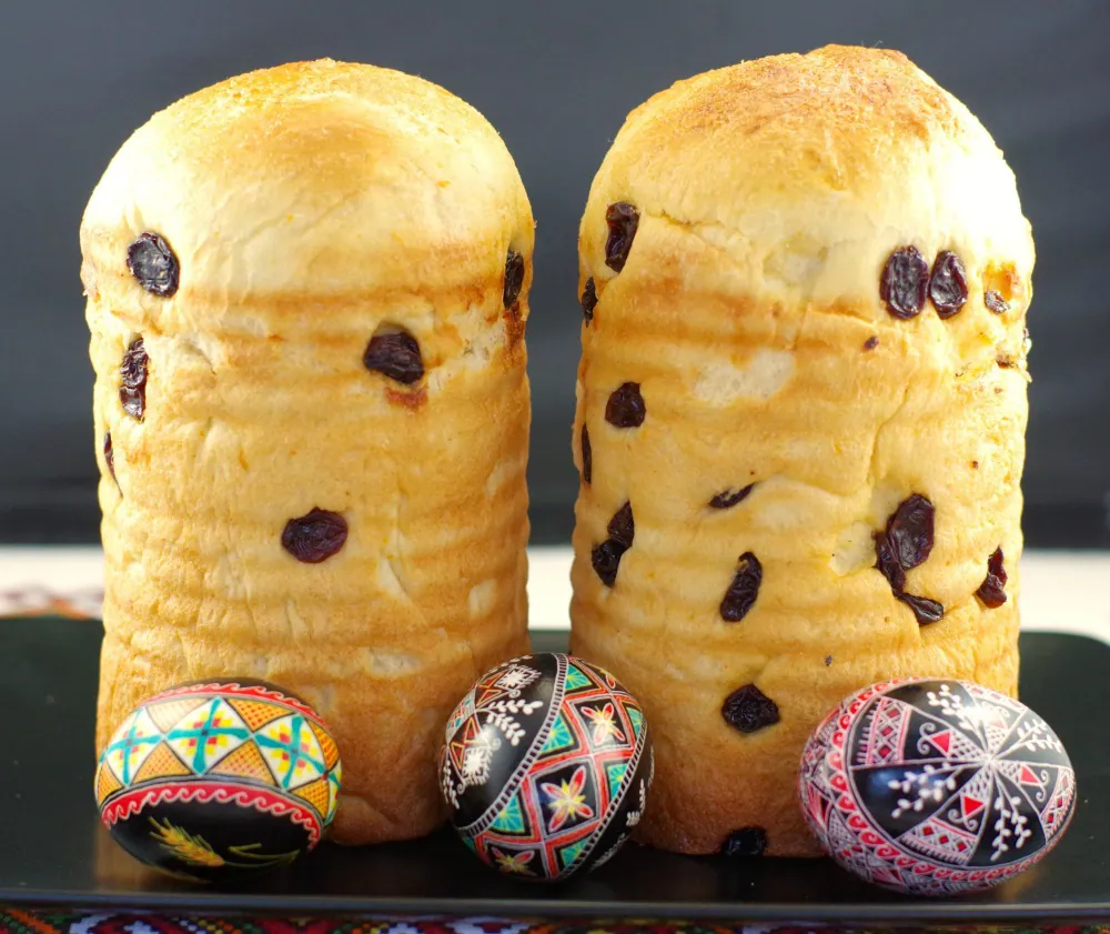 2 loaves of Babka Ukrainian Easter Bread on a black tray with Ukrainian Easter eggs in front