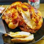 WW BBQ beer can chicken on a black serving plate with a knife and can of beer in the background
