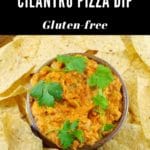Bowl of gluten-free artichoke and cilantro pizza dip surrounded by nachos