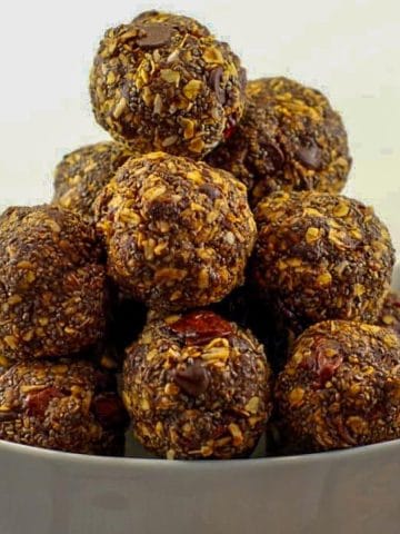 chocolate cherry energy balls stacked in a white bowl