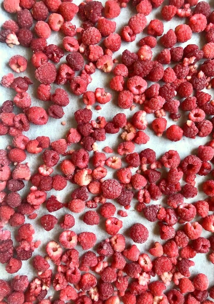 Frozen raspberries on parchment lined cookie sheet