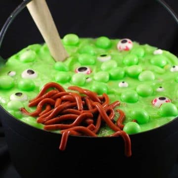 Halloween dessert witches brew trifle, with jello worms in black cauldron, with wooden spoon