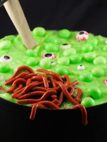 Halloween dessert witches brew trifle, with jello worms in black cauldron, with wooden spoon