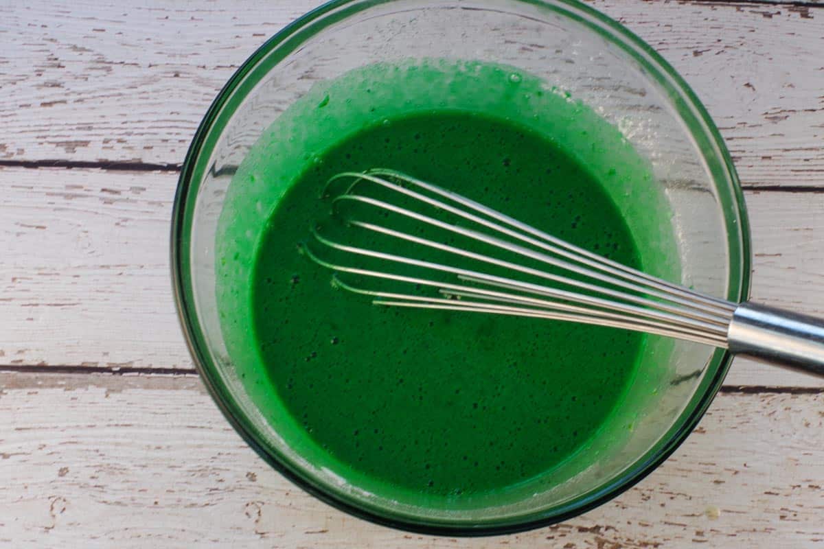 Flour mixture, food coloring and lime zest whisked into the large glass bowl with egg mixture.