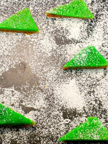 lime squares with powdered sugar on a cutting board with powdered sugar and space where one has been removed