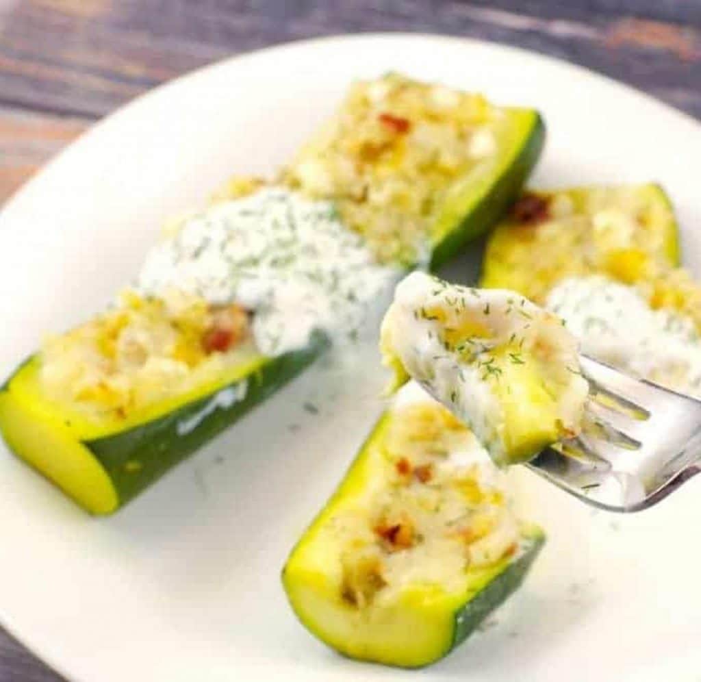 pierogi stuffed zucchinis on a plate with fork holding up a piece of it