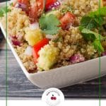 pinterest pin with photo of quinoa salad in white bowl and black and green text on white background on bottom