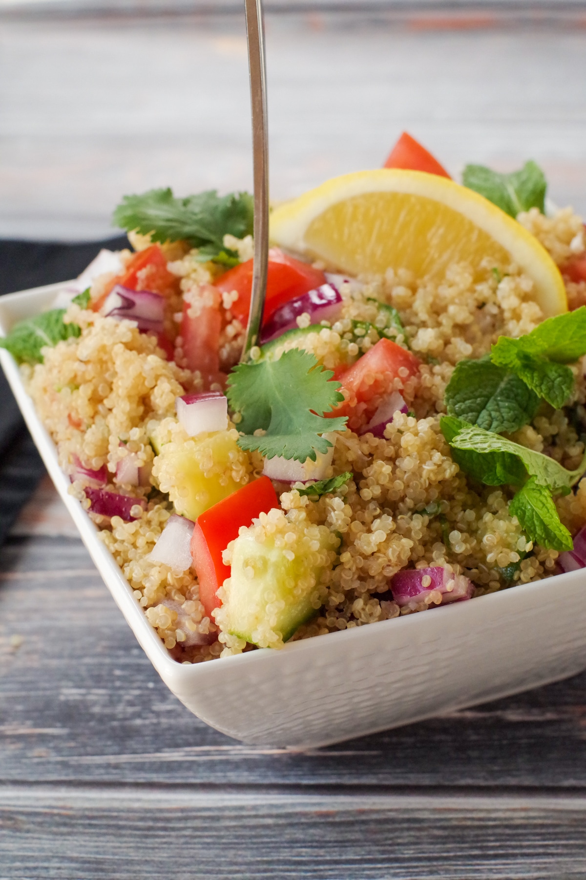 Greek quinoa salad in white bowl