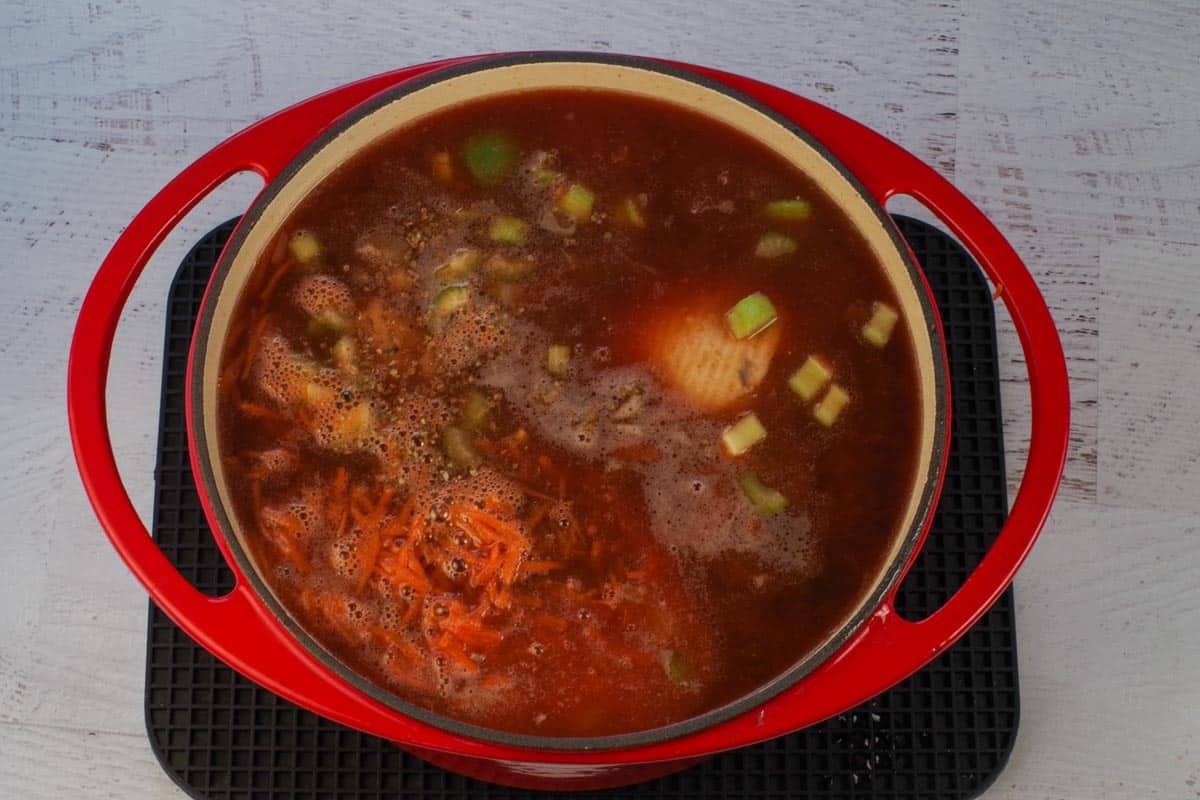 remaining carrot soup ingredients added to orange Dutch oven