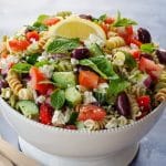 Greek pasta salad in white bowl