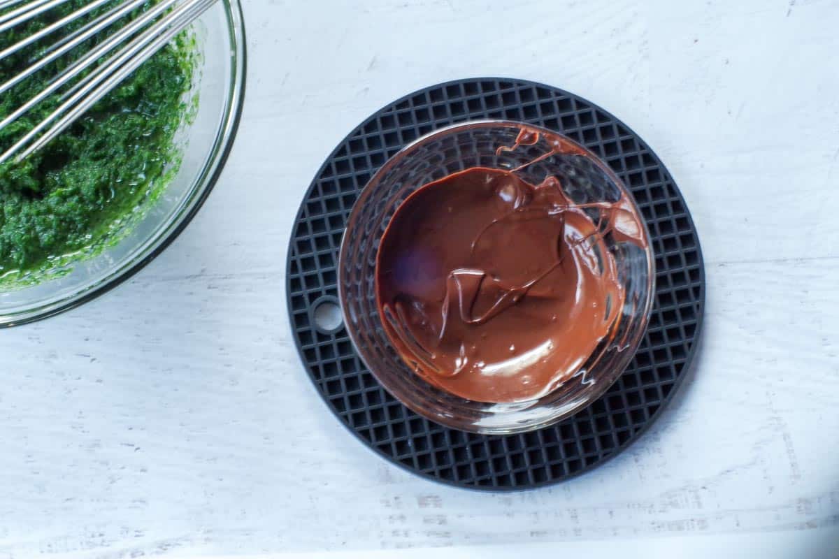 chocolate melted in small glass bowl, sitting on black trivet