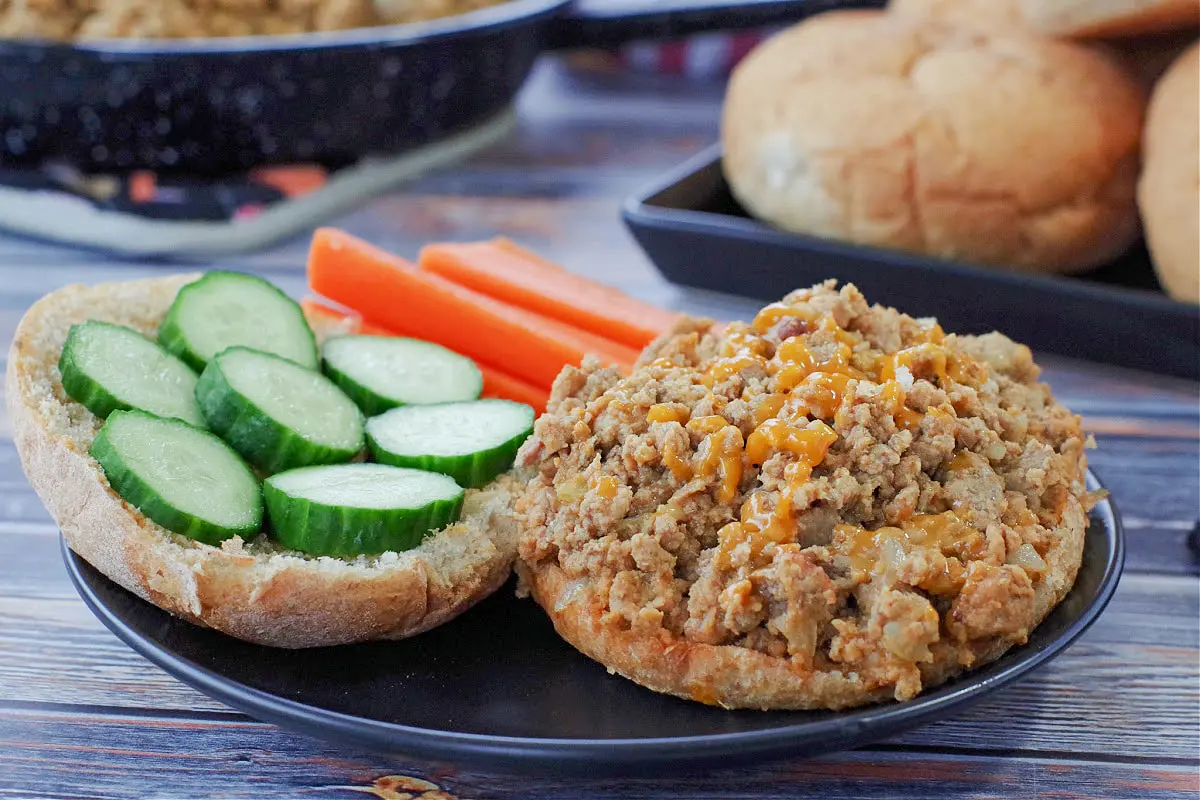 photo of weight watchers turkey sloppy joes on a black plate with carrots and cucumbers