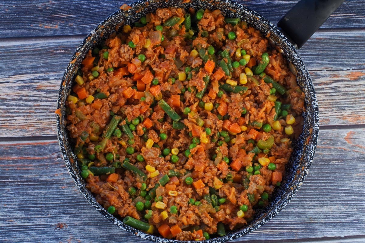 Vegetables, turkey and other sauce ingredients added to parsnip mixture in frying pan.