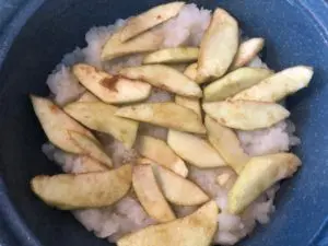 first layers of turnips and apples in blue casserole dish