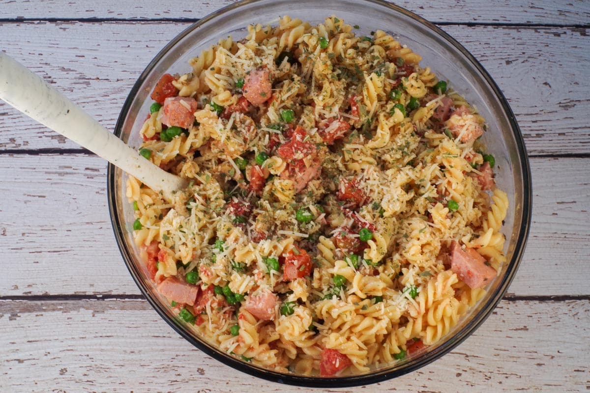 Pasta added to ham mixture in large glass bowl.