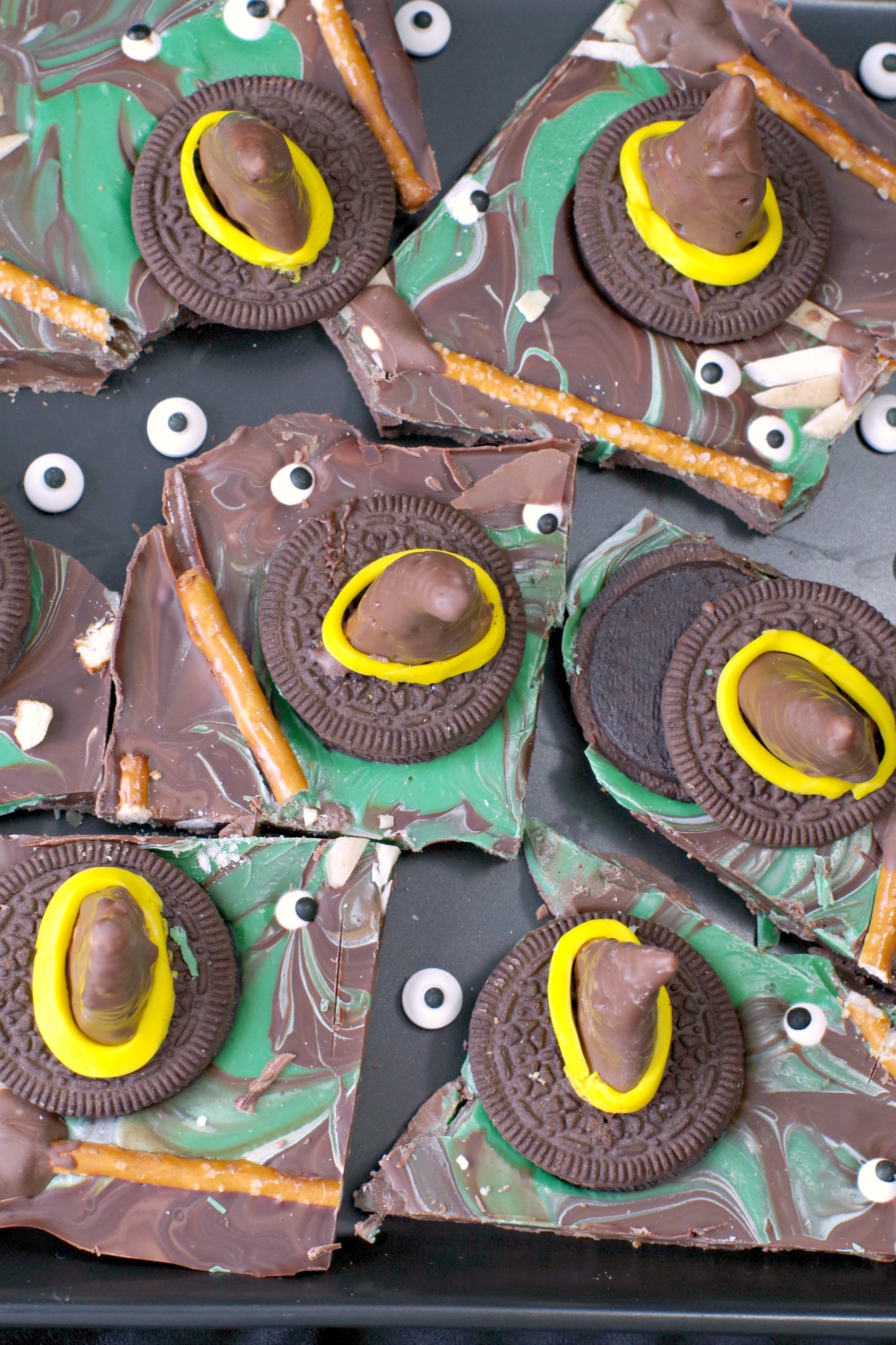 Melting Witch Halloween Chocolate Bark broken into pieces on black platter with extra candy eyes scattered on plate