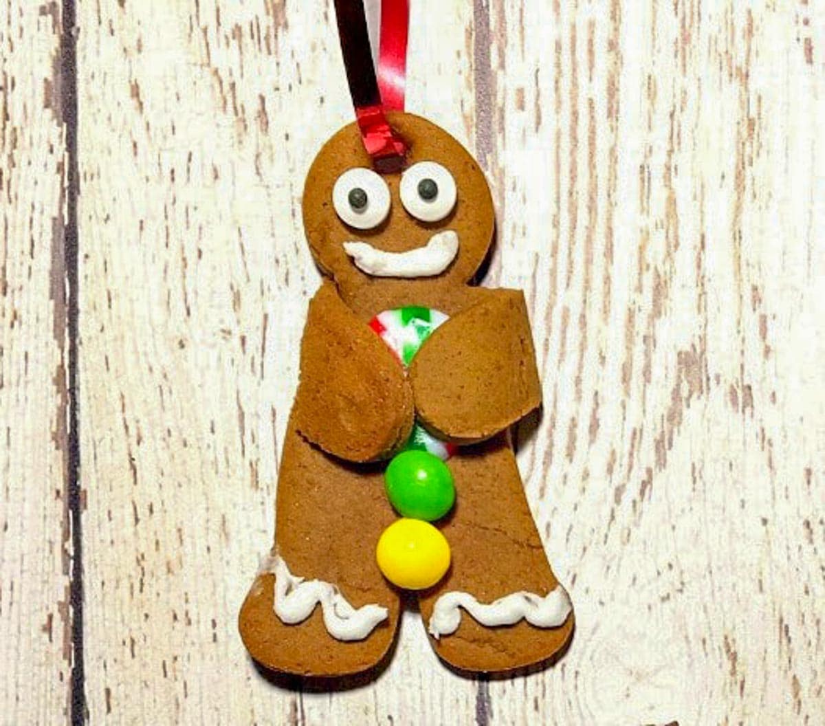 gingerbread man cookie (with string at top for decoration) on white faux wood surface