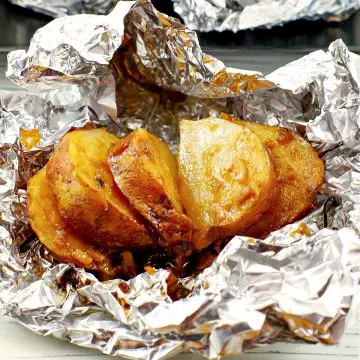 cooked, sliced, onion baked potato on foil