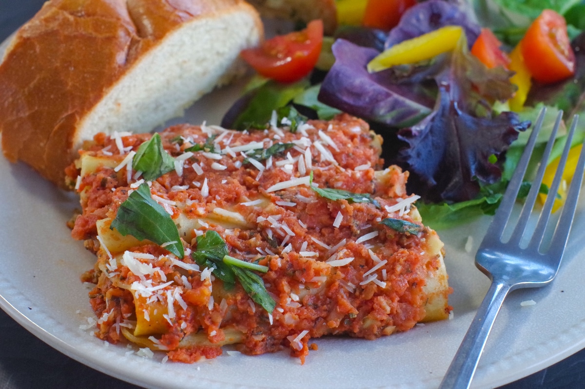 beef cannelloni on plate with garlic toast and garden salad