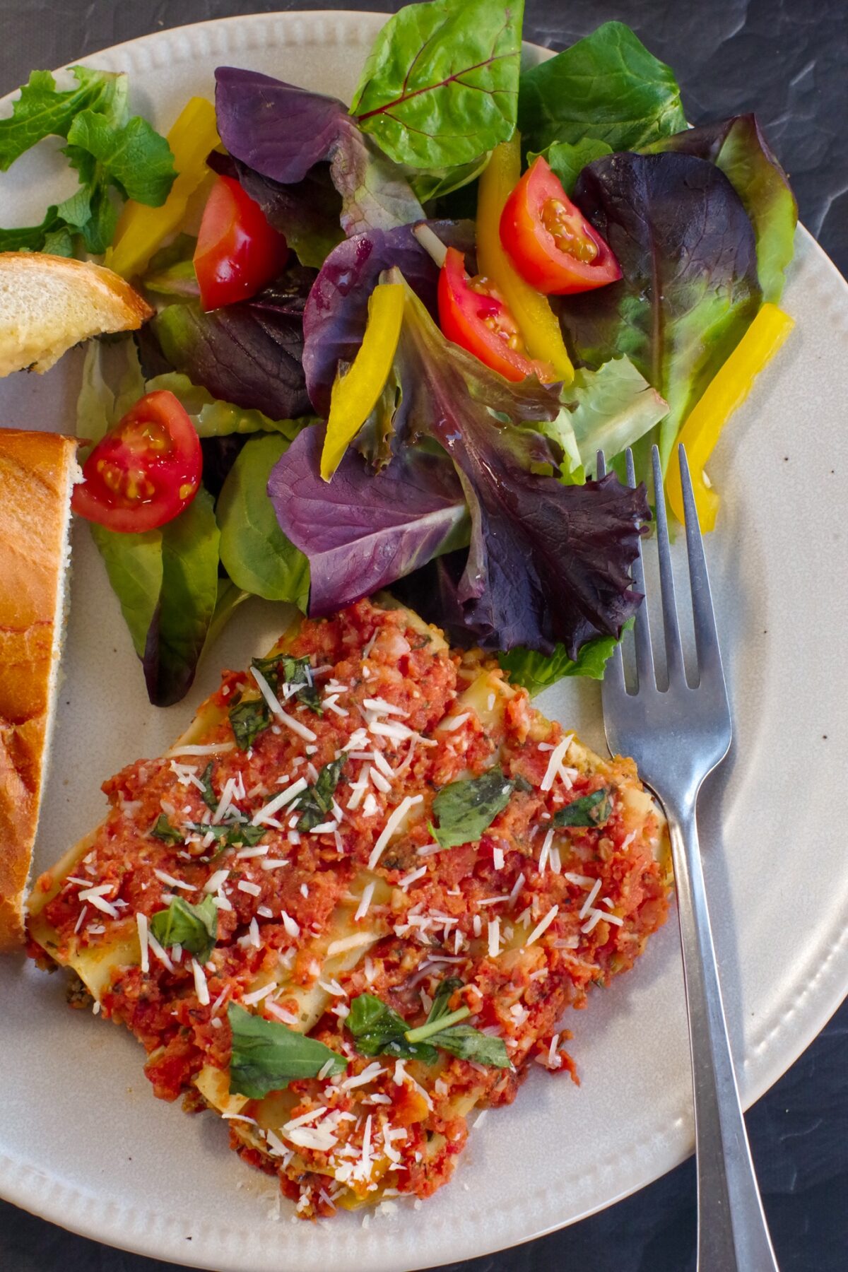 beef cannelloni on plate with garlic toast and garden salad