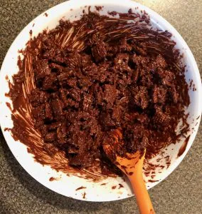 Cereal mixture completely covered in chocolate in white bowl