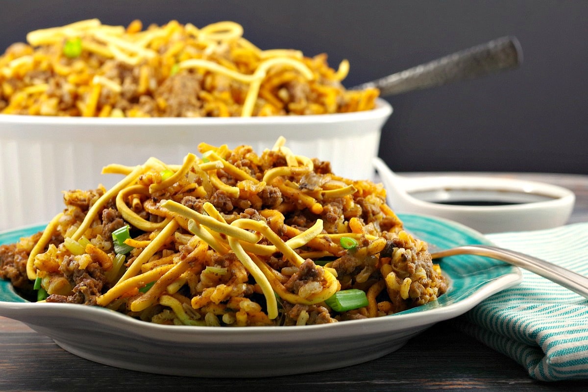 Chow Mein Hotdish casserole on a plate in front with casserole dish in background