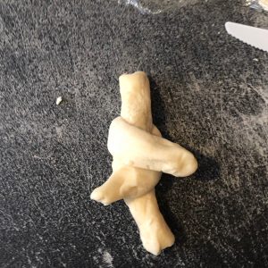 the other side of the dough cross is pulled across to opposite side
