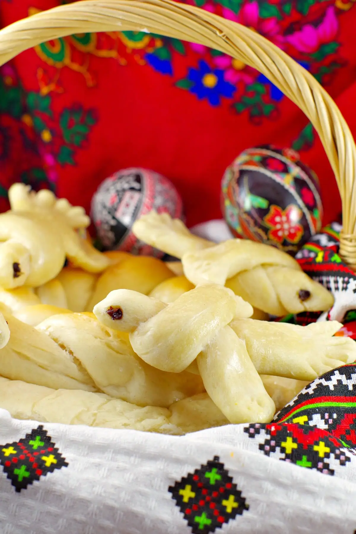 Ukrainian Easter bread doves in basket with Ukrainian Easter Eggs in background