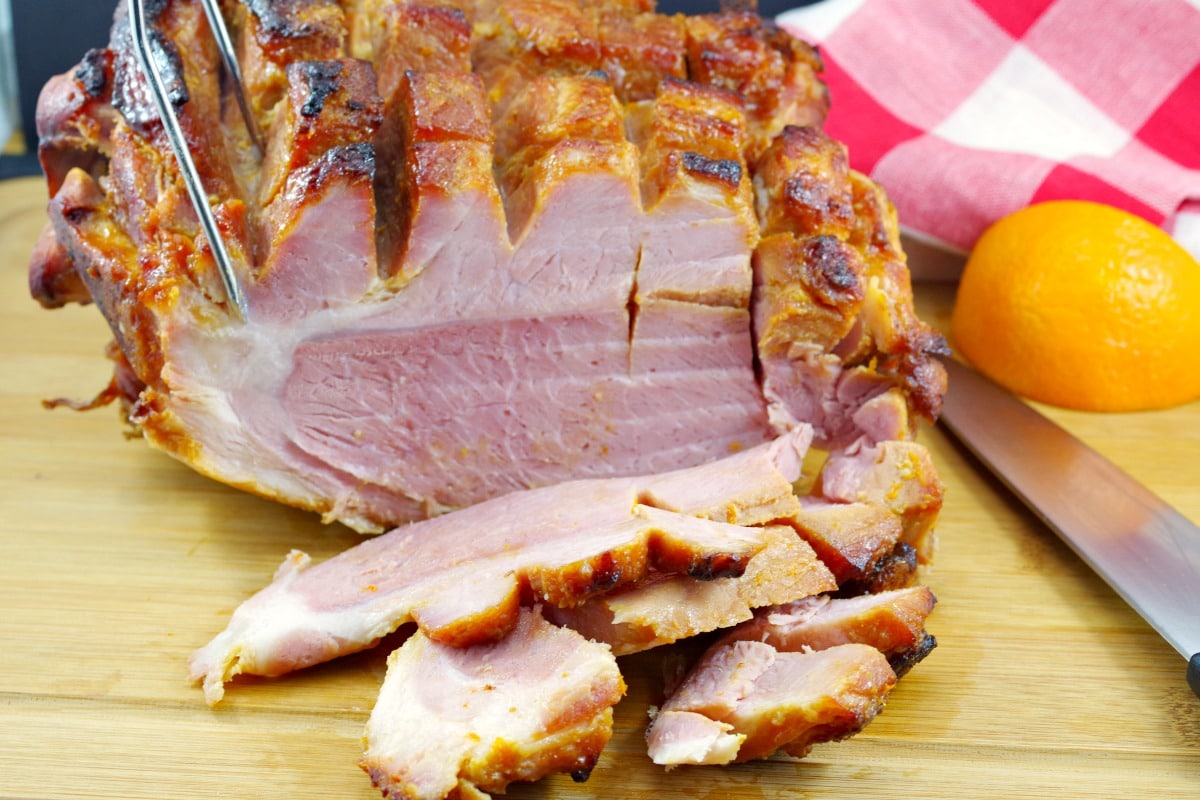 Whole picnic ham with orange glaze, sliced in front