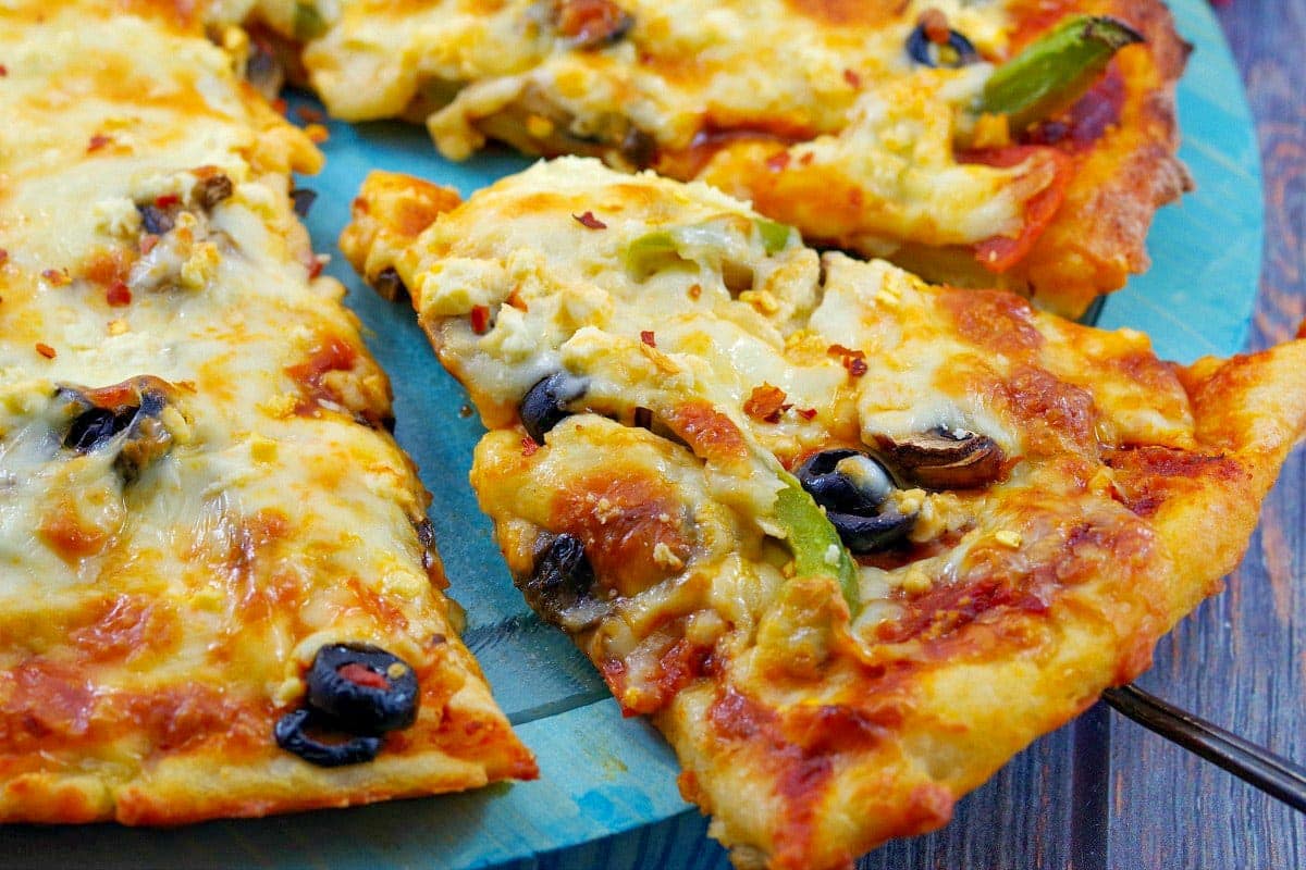 slice of weight watchers pizza being lifted off a blue pizza plate