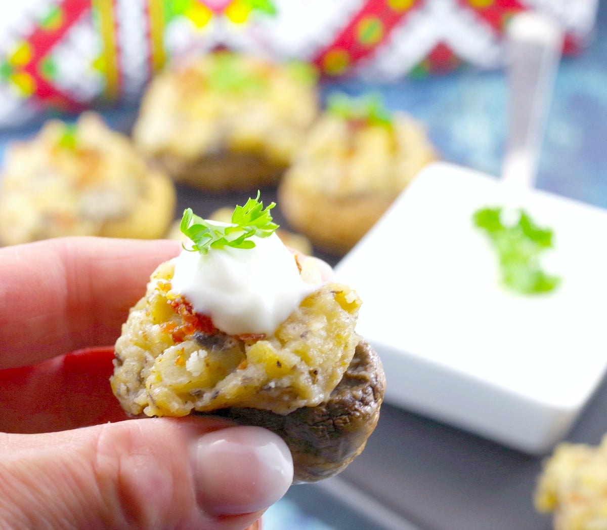 Pierogi stuffed mushroom being held up between thumb and forefinger