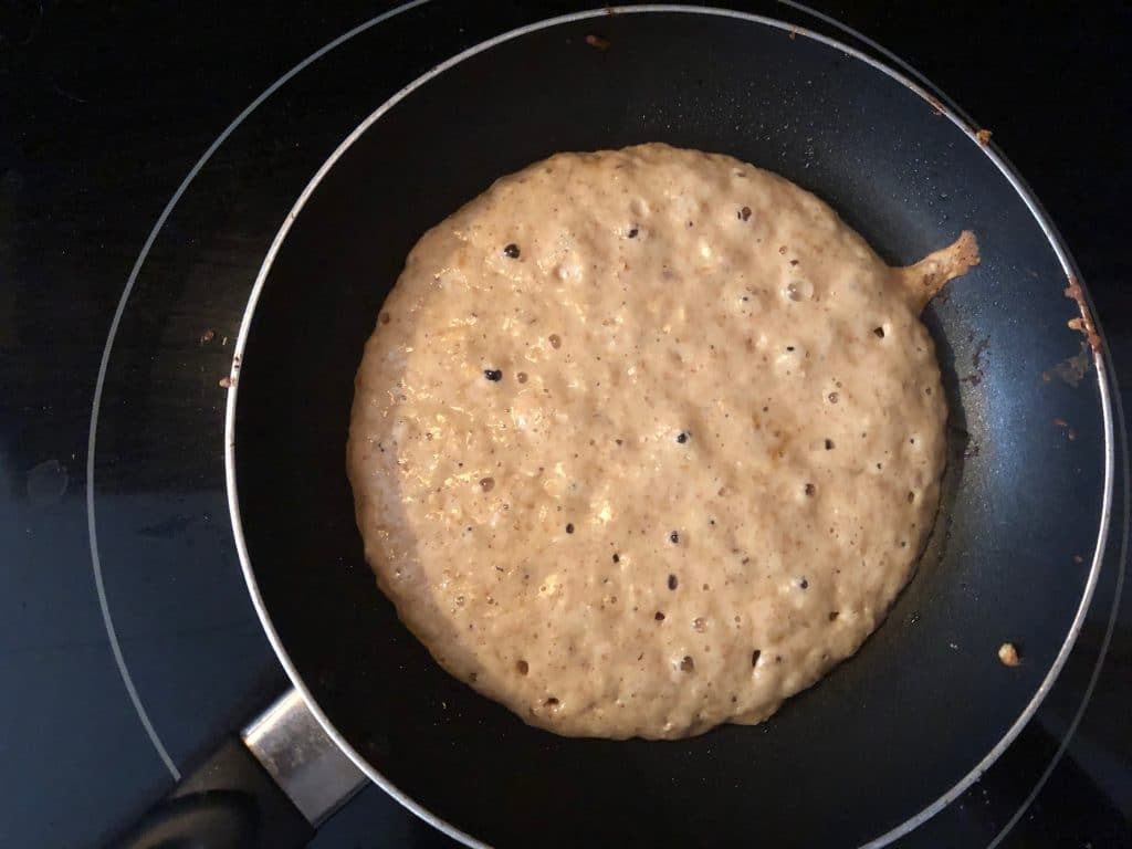 pancake starting to bubble in frying pan