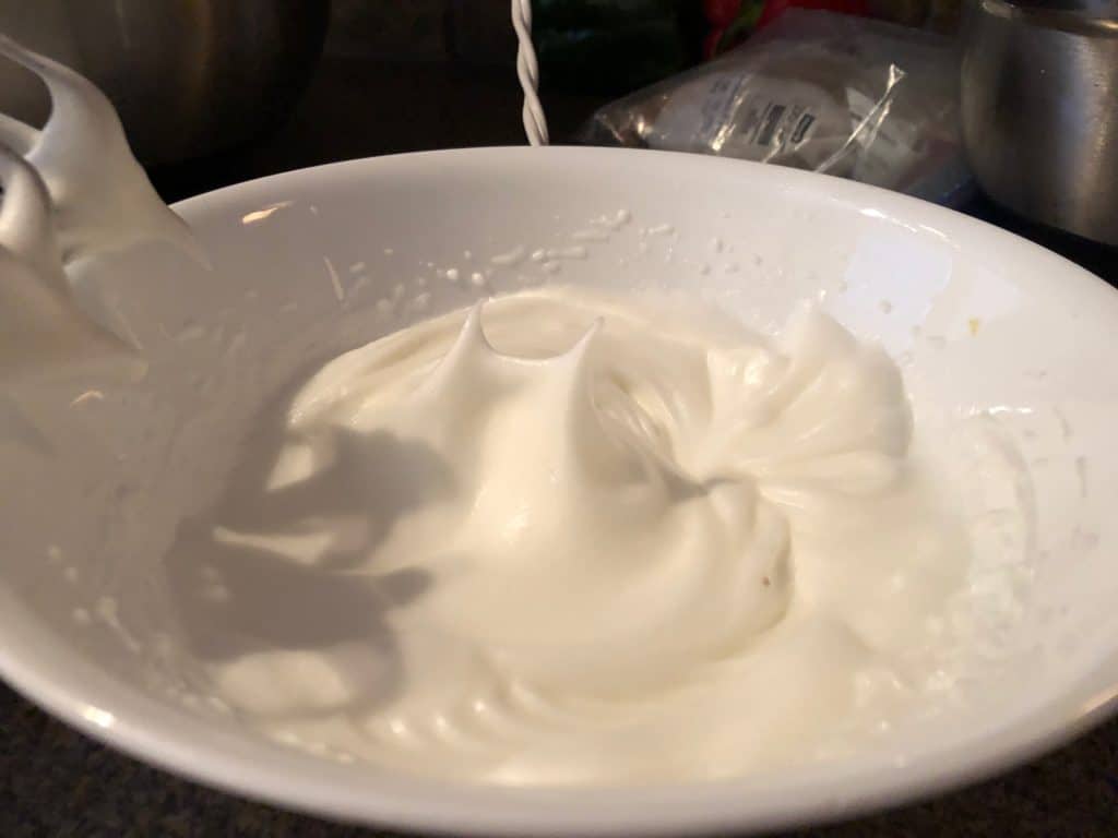 egg whites beaten to stiff peaks in white bowl