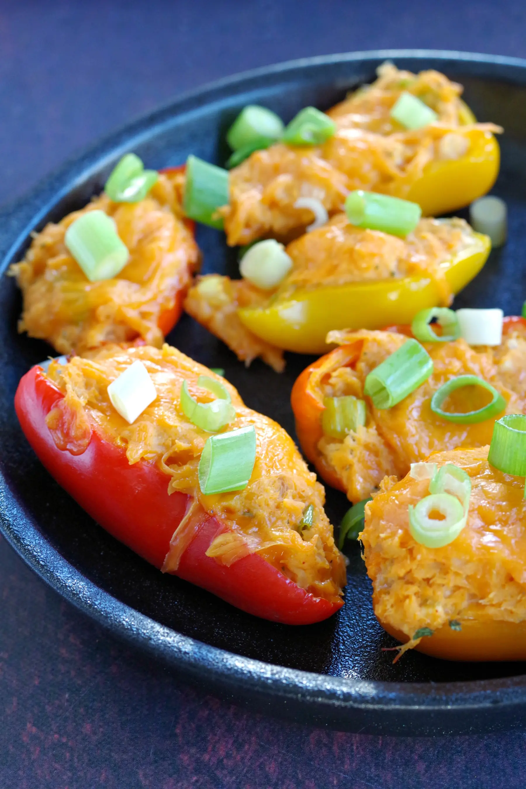 half a dish of chicken stuffed peppers on a black appetizer dish