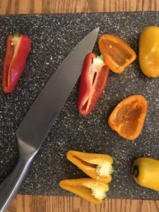 peppers on cutting board with knife