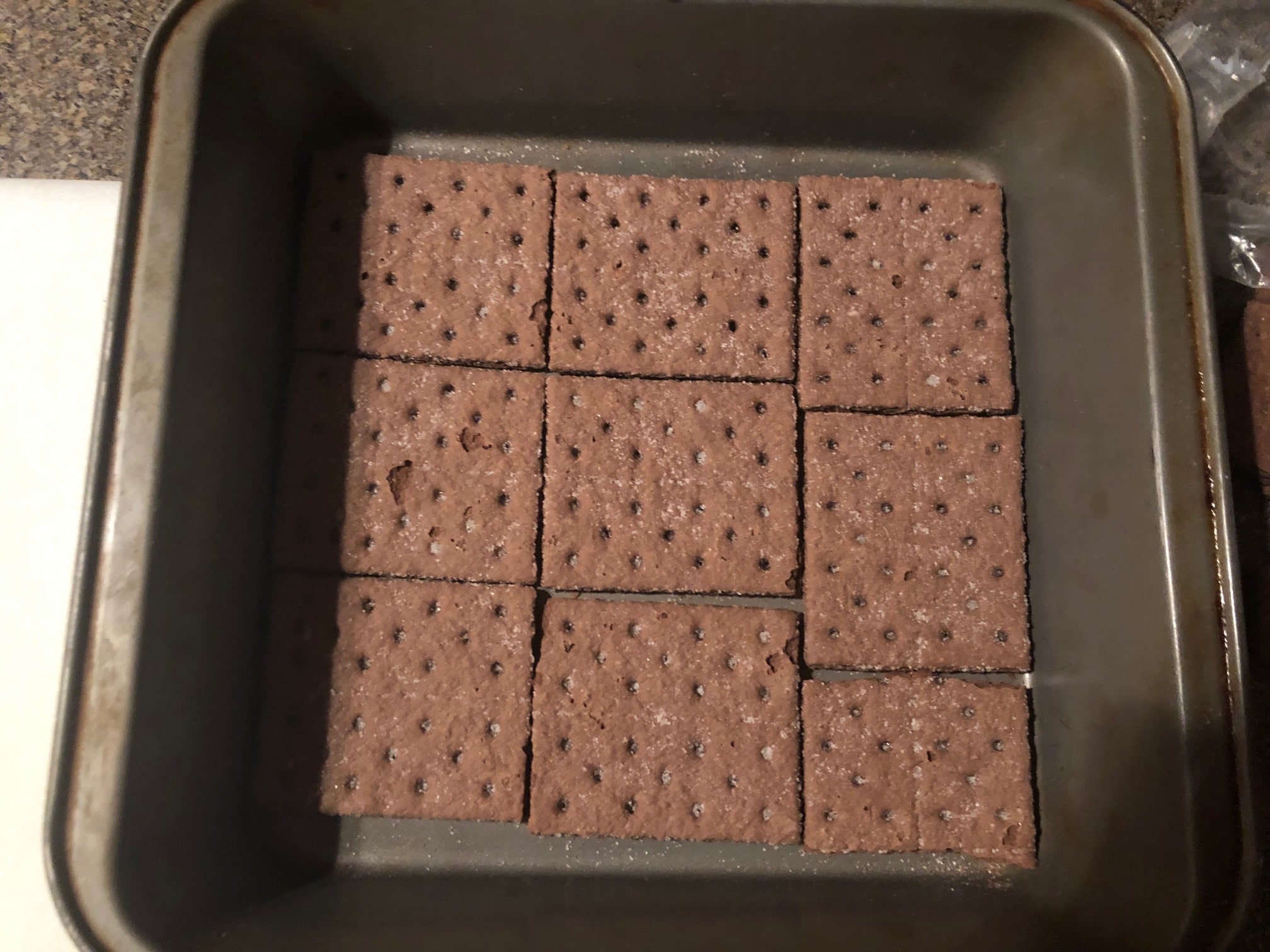 chocolate graham crackers lining bottom of pan