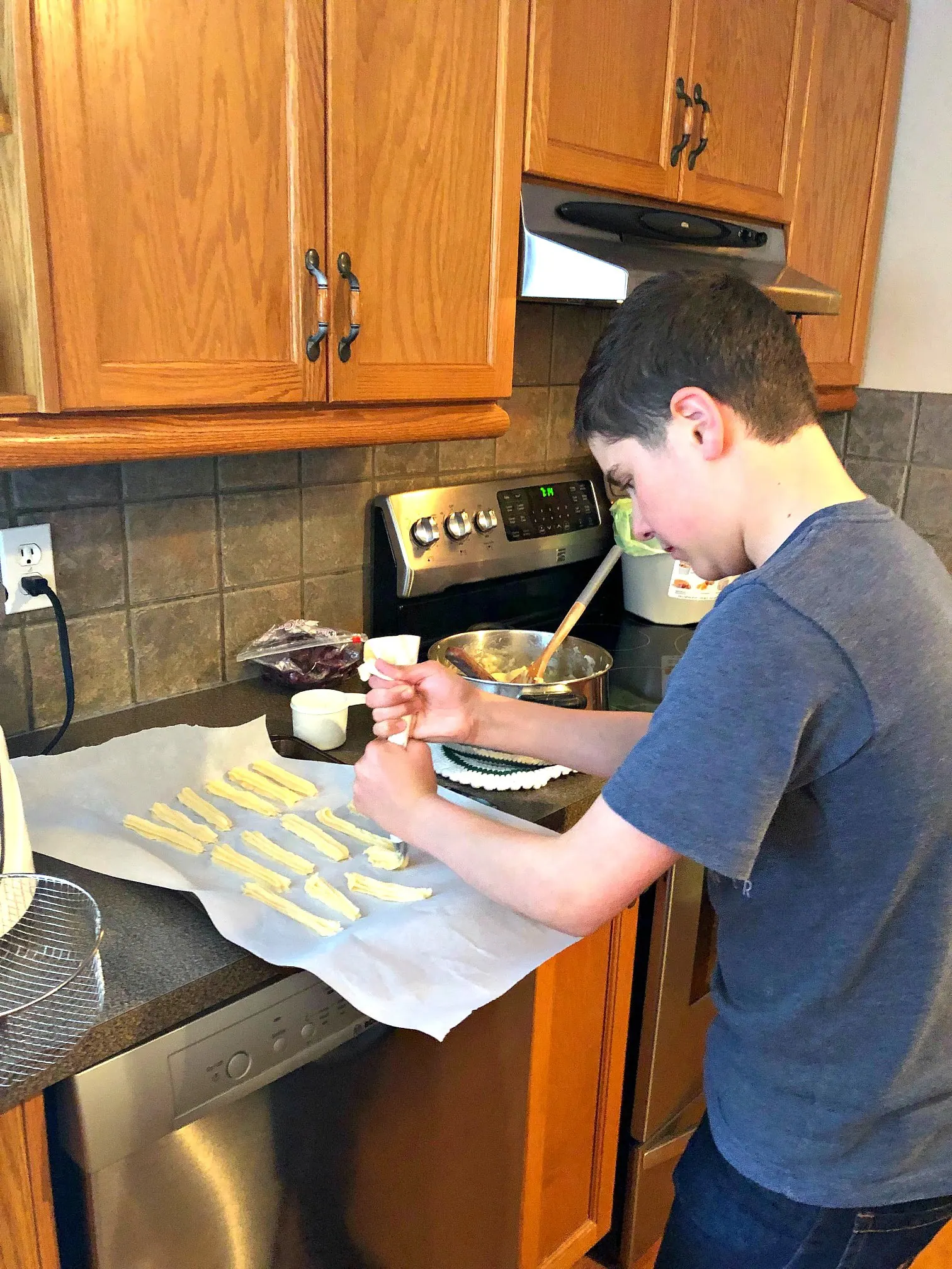 teenage boy making churros