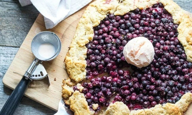 Saskatoon Berry Galette with ice cream on top and a ice cream scoop on the side
