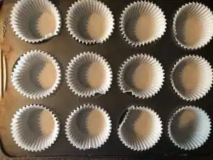 Muffin tin lined with empty paper muffin cups