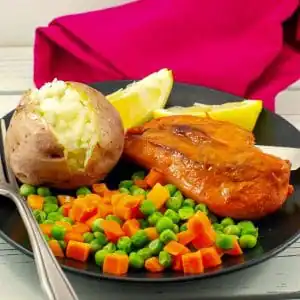 Bonanza Monterey chicken on plate with baked potato and mixed vegetables