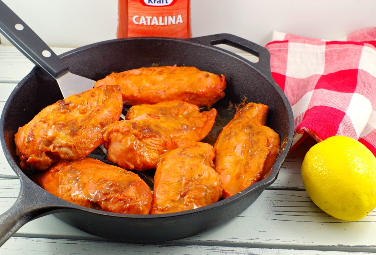 Chicken Monterey in a frying pan with catalina dressing in background