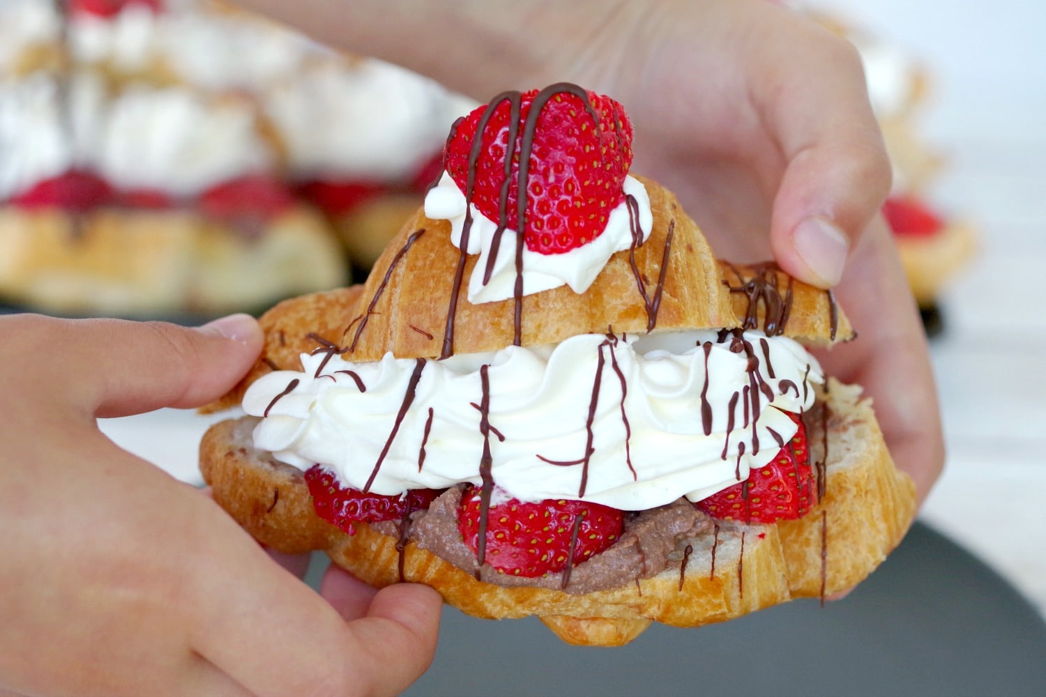 Strawberry Eclair being held in child's hands