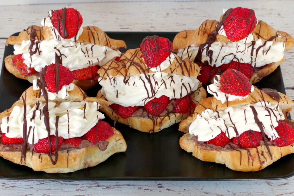 Strawberry eclairs on black serving tray