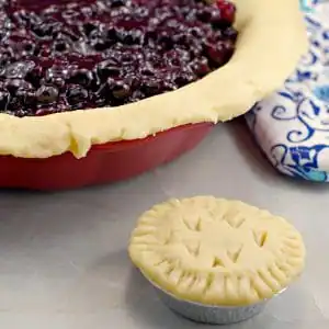 No Fail Pie Crust filled with Saskatoon berry pie filling and mini pie in front