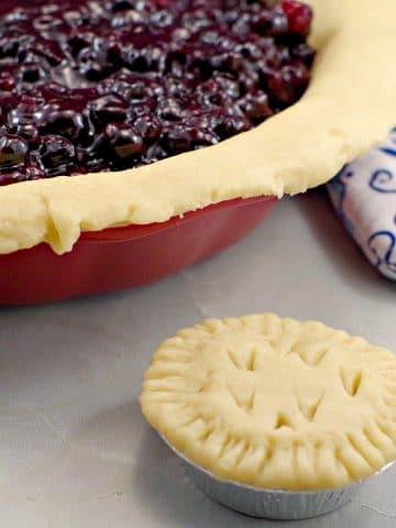 No Fail Pie Crust filled with Saskatoon berry pie filling and mini pie in front